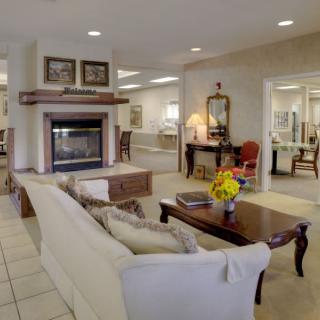 A cozy and elegantly decorated living room featuring a fireplace, sofa, and coffee table.
