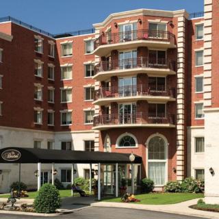 A brick hotel building with an entrance canopy and balconies.