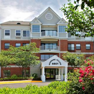 A residential apartment building with a landscaped front entrance.