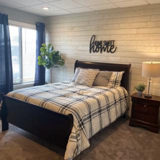 A cozy, modern bedroom featuring a stylish bed, soft bedding, and decorative elements that create a welcoming atmosphere.