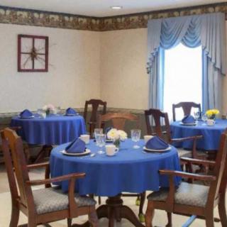 An elegantly decorated dining room with blue tablecloths and floral centerpieces.