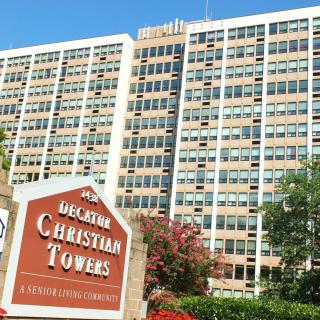 A tall residential building with a sign labeled 'Decatur Christian Towers'.