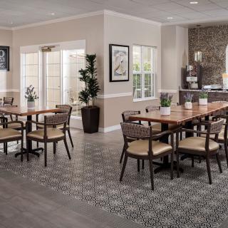 A modern dining room with wooden tables and chairs, featuring natural lighting and contemporary decor.