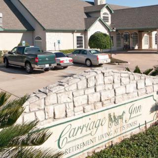Carriage Inn retirement home with a visible parking area and sign in front.