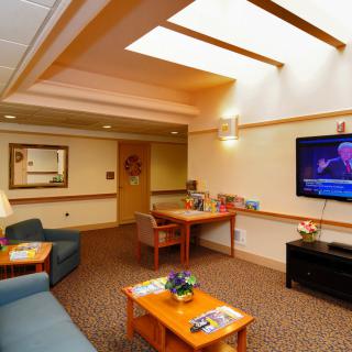A cozy living room with comfortable seating, a television, and warm lighting.