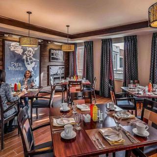 A cozy restaurant dining area set up for breakfast, featuring neatly arranged tables and stylish decor.