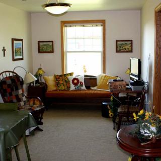 A cozy living room with a sofa, television, and various decorations.