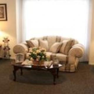 A cozy living room with a sofa and coffee table adorned with a floral arrangement.