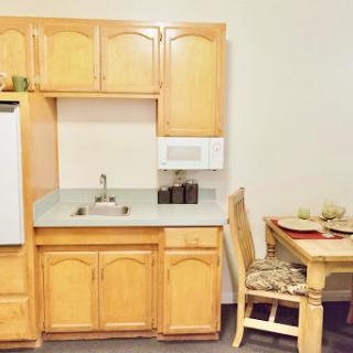 A cozy kitchen setting featuring wooden cabinetry and a small dining area.