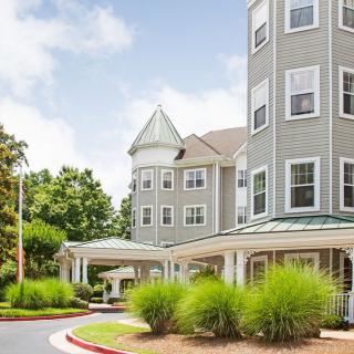A beautiful multi-story residential building with a tower and well-maintained landscaping.