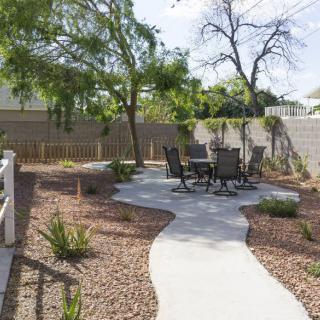 A well-maintained backyard with a winding pathway and outdoor seating area.