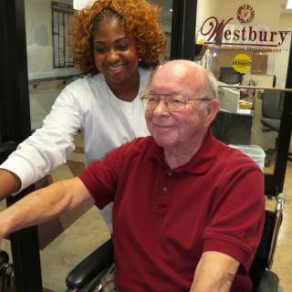 A caregiver and an elderly man sharing a joyful moment indoors.