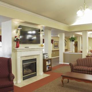 A cozy living room with a fireplace and television, featuring comfortable seating and warm lighting.