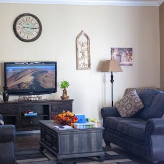 A cozy living room featuring comfortable seating, a television for entertainment, and decorative accents.