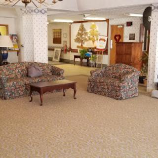 A cozy living room setup featuring patterned sofas and a coffee table, surrounded by decorative art.