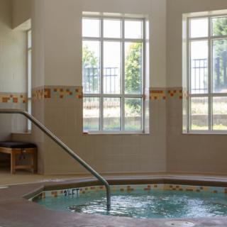 Indoor jacuzzi with large windows and natural light.