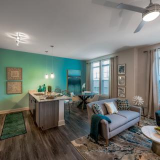 A modern open-concept apartment with a stylish living room and kitchen area.