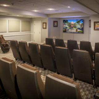 A cozy home theater with multiple rows of seats and a large screen.
