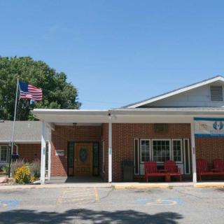 The exterior of a motel with an entrance and an American flag.