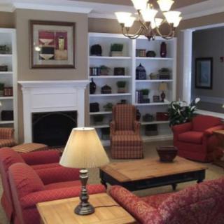 A cozy living room featuring comfortable seating, a fireplace, and decorative bookshelves.