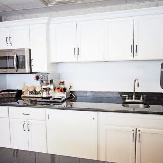A modern kitchen with white cabinets and a granite countertop.