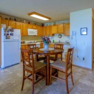 A cozy kitchen and dining area featuring wooden cabinets and a round table with chairs.