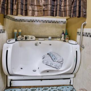 A bathroom with a jacuzzi tub, featuring towels and a decorative curtain.