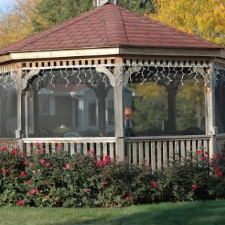 A charming gazebo surrounded by blooming flowers in a serene garden setting.