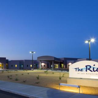A well-lit building exterior at night with clear signage.
