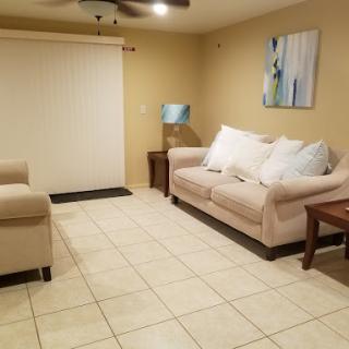 A cozy living room featuring a light-colored sofa, an armchair, and decorative art.