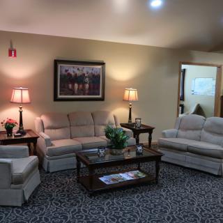 A cozy living room with sofas, lamps, and a central coffee table.