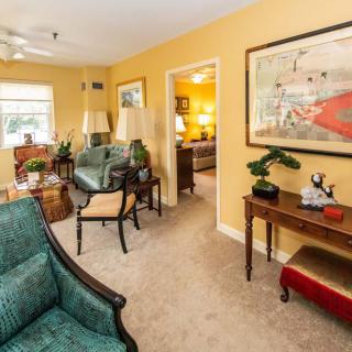 A cozy living room with yellow walls, featuring comfortable seating and tasteful decor.