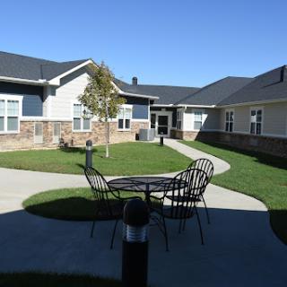 A peaceful courtyard featuring outdoor seating and well-maintained greenery, perfect for relaxation.