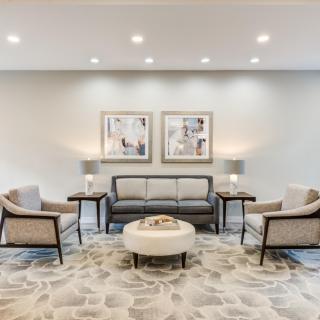 A modern living room with a central sofa, chairs, and elegant decor.