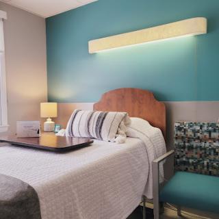 A cozy hotel room featuring modern decor and a calming blue accent wall.
