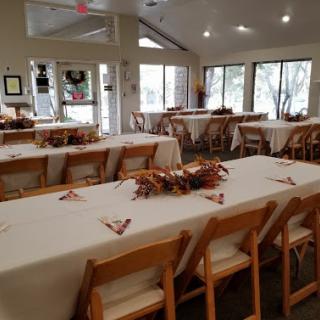 A spacious dining area set up for an event, featuring neatly arranged tables and chairs with a bright, inviting atmosphere.