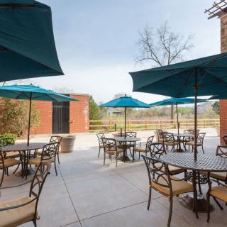 An outdoor patio with tables and umbrellas on a sunny day.