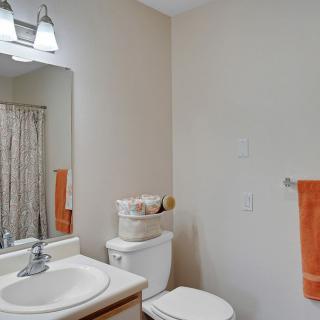 A clean and simple bathroom with a mirror, sink, and toilet.