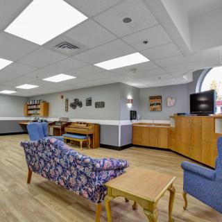 A bright and spacious waiting room with comfortable seating and a television.