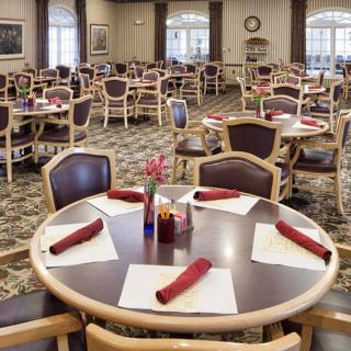 A well-arranged dining room with neatly set tables and chairs, ready for guests.