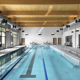A modern indoor swimming pool with sleek architectural design and ample lighting.