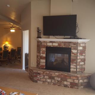 A cozy living room featuring a brick fireplace topped with a mounted TV.