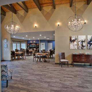 A stylish and spacious dining area with modern decor and elegant chandeliers.