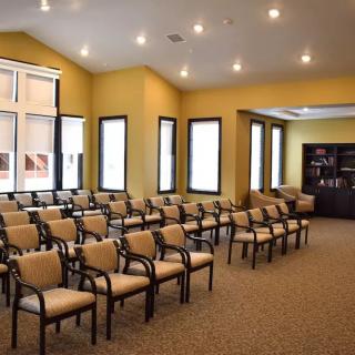 A well-lit conference room with rows of chairs arranged for a meeting.