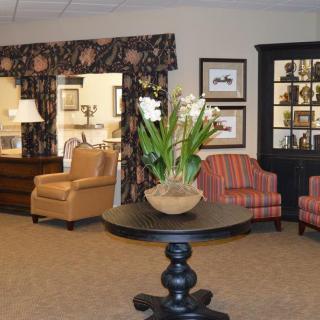 A cozy living room featuring comfortable seating, decorative elements, and a central table with a potted plant.