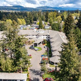 Aerial view of a large building surrounded by trees and natural landscape.