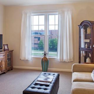 A cozy living room with a large window, couch, and elegant furnishings.