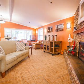 A cozy living room featuring warm orange walls and comfortable seating, perfect for relaxation.