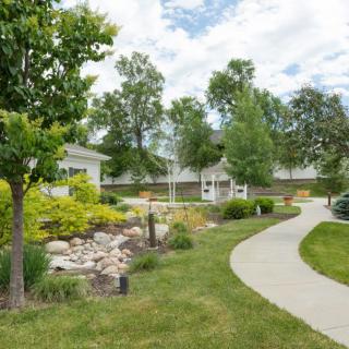 A serene garden featuring a winding pathway, lush greenery, and a charming gazebo.