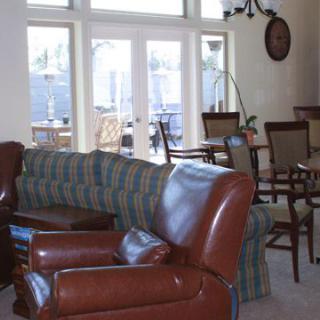 A cozy living room with leather chairs and a large window letting in natural light.